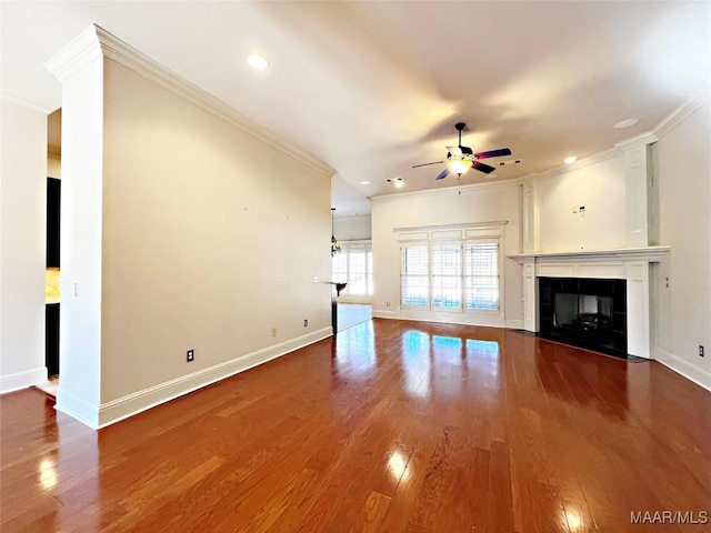 unfurnished living room featuring crown molding, baseboards, a tiled fireplace, and wood finished floors