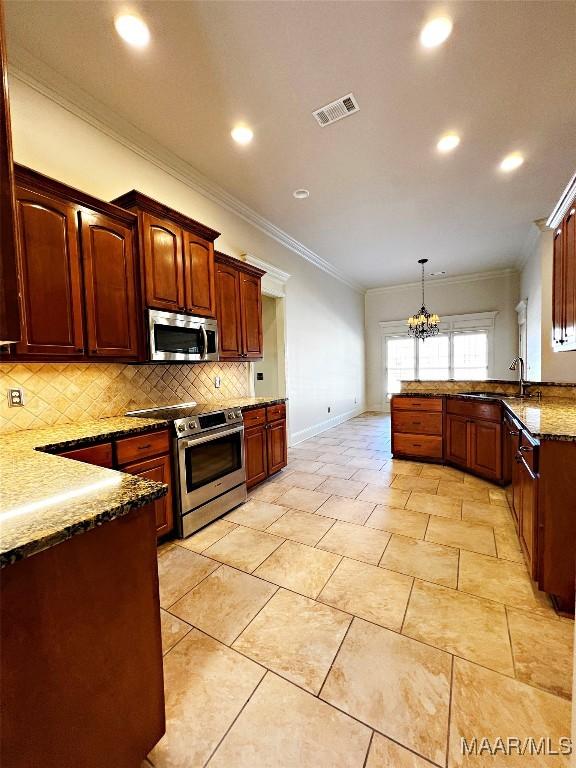 kitchen featuring stainless steel appliances, visible vents, backsplash, a sink, and a peninsula