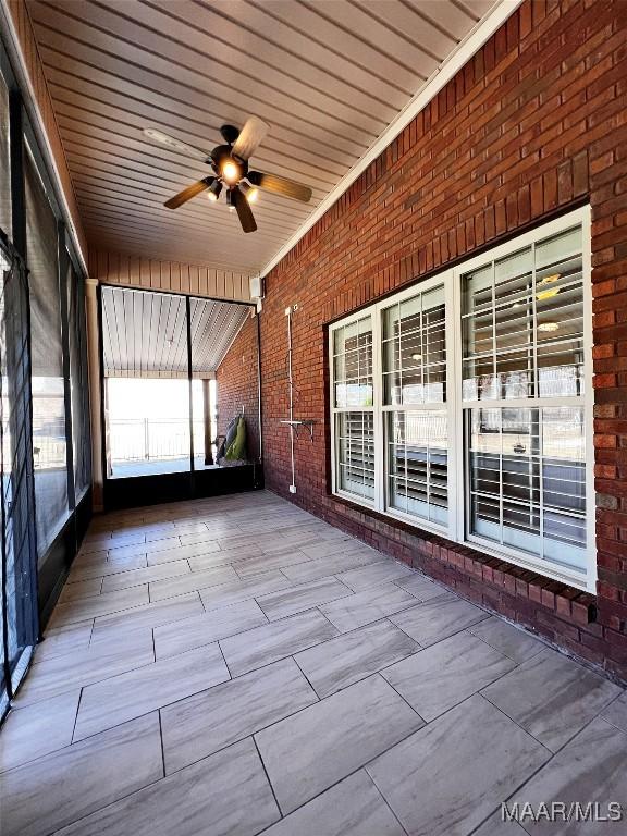 unfurnished sunroom featuring ceiling fan