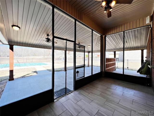 unfurnished sunroom with ceiling fan