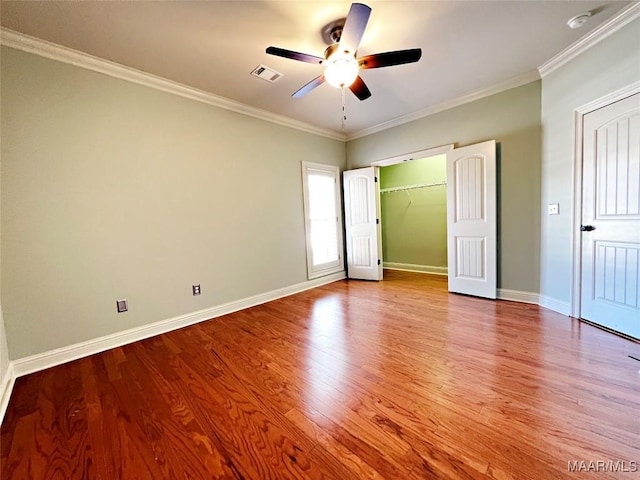 unfurnished bedroom with crown molding, visible vents, and wood finished floors