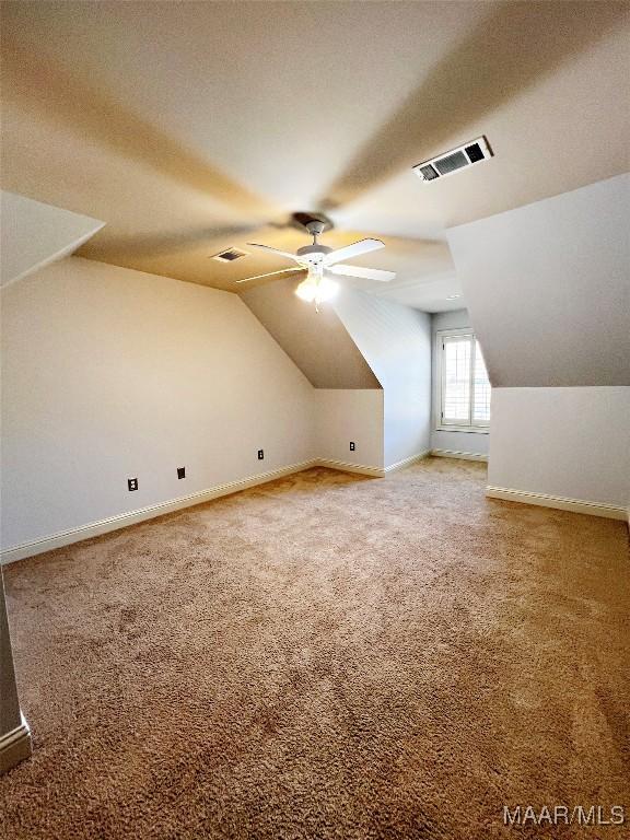 bonus room with lofted ceiling, ceiling fan, visible vents, and light colored carpet