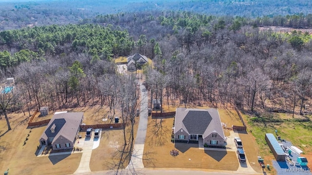 bird's eye view with a wooded view