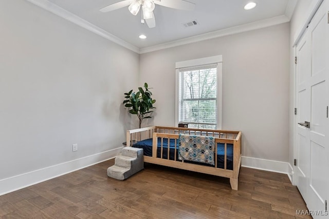 bedroom featuring baseboards, ornamental molding, and wood finished floors