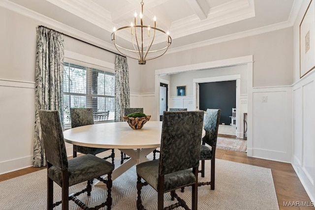 dining area with a chandelier, wood finished floors, a decorative wall, and ornamental molding