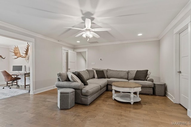 living room featuring visible vents, baseboards, a ceiling fan, light wood finished floors, and crown molding