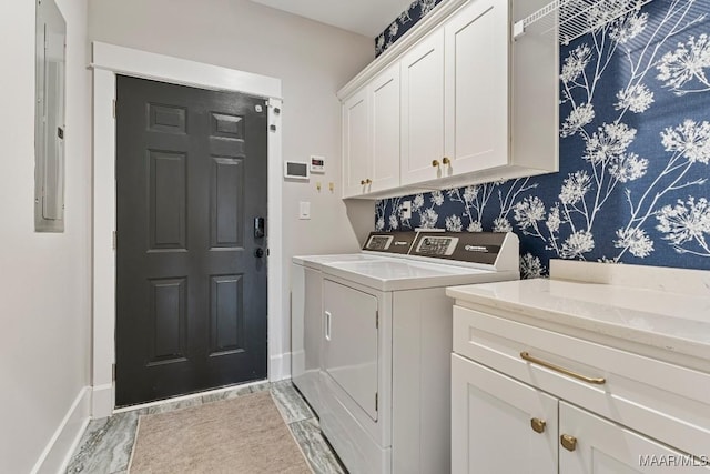 laundry area with separate washer and dryer, electric panel, cabinet space, and baseboards