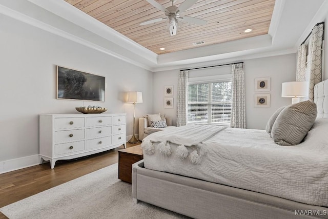 bedroom with a tray ceiling, wooden ceiling, crown molding, and wood finished floors