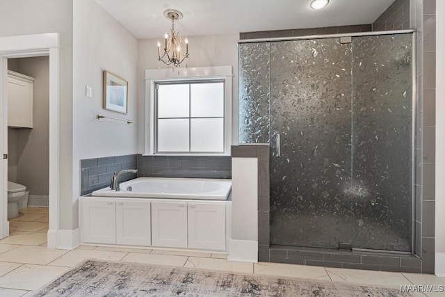 bathroom with a chandelier, a shower stall, toilet, and a bath