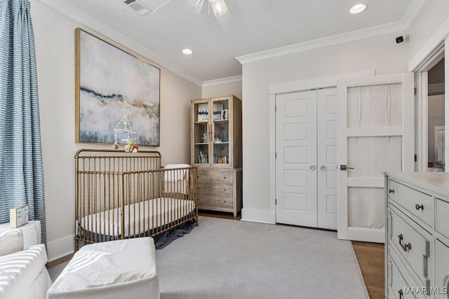 bedroom featuring baseboards, crown molding, visible vents, and wood finished floors