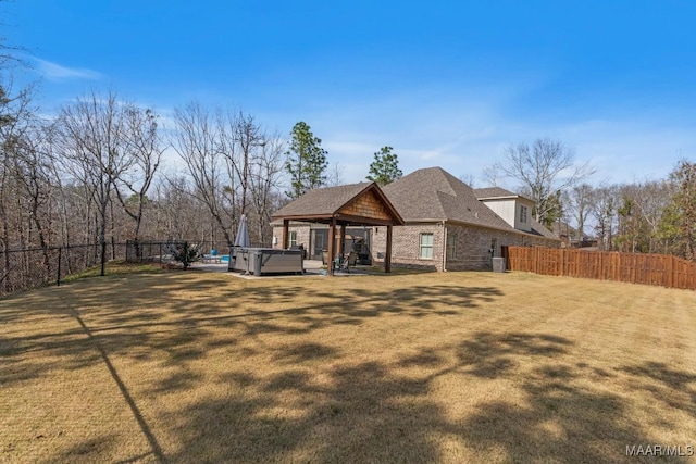 rear view of house featuring a yard, fence, a hot tub, and a gazebo