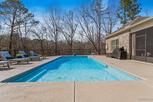 view of swimming pool with a patio area, fence, a fenced in pool, and area for grilling