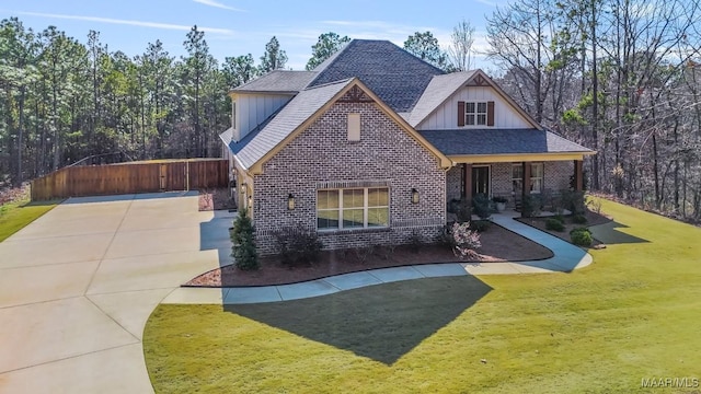 view of front facade with roof with shingles, a front lawn, a porch, board and batten siding, and brick siding