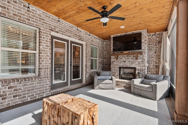 view of patio featuring an outdoor brick fireplace and a ceiling fan