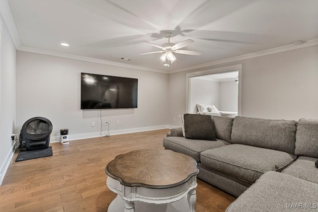 living area with ornamental molding, wood finished floors, a ceiling fan, and baseboards