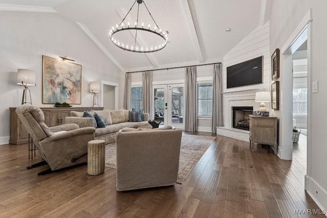 living room with dark wood-style floors, french doors, a notable chandelier, a large fireplace, and high vaulted ceiling