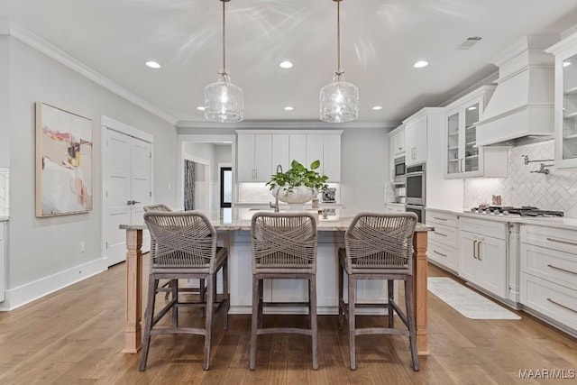 kitchen featuring appliances with stainless steel finishes, glass insert cabinets, white cabinetry, and crown molding