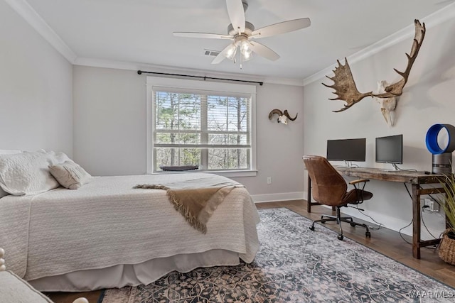 bedroom with crown molding, visible vents, a ceiling fan, wood finished floors, and baseboards