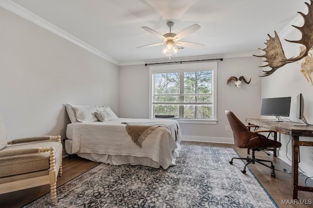 bedroom with baseboards, crown molding, and wood finished floors