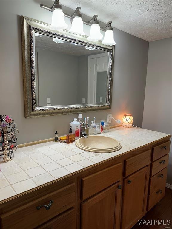 bathroom with vanity and a textured ceiling