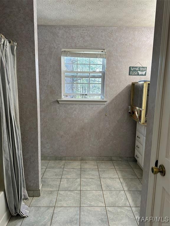 full bath with tile patterned floors and a textured ceiling