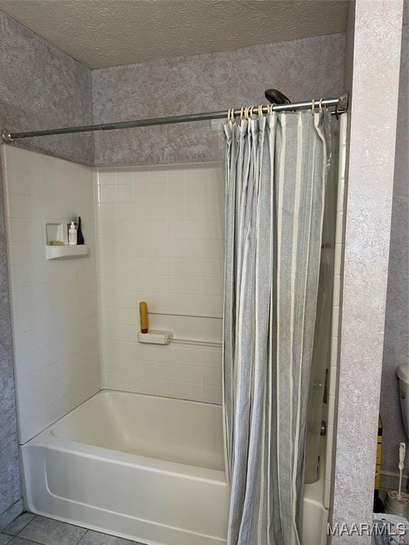 bathroom featuring tile patterned flooring, shower / tub combo, a textured ceiling, and toilet