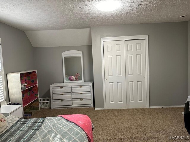 carpeted bedroom with baseboards, a closet, a textured ceiling, and lofted ceiling