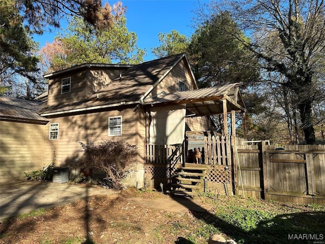 view of home's exterior featuring metal roof and fence