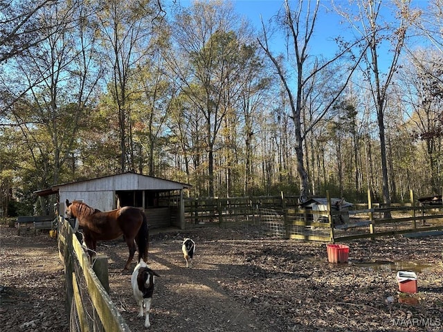 view of yard featuring a view of trees, an exterior structure, and an outdoor structure