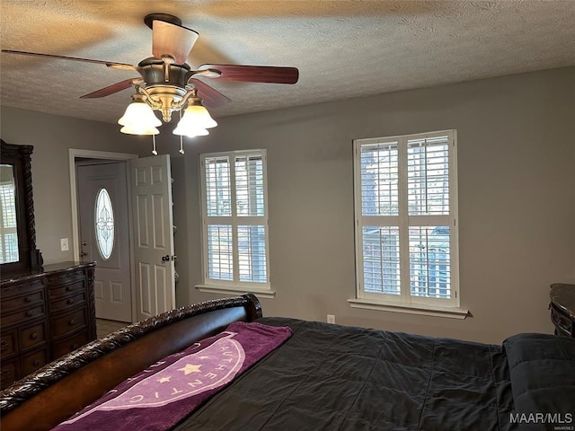unfurnished bedroom with a ceiling fan, multiple windows, and a textured ceiling