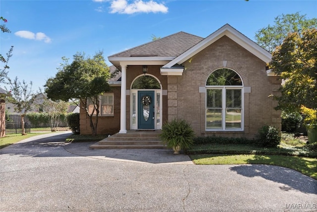 view of front of home with brick siding and a shingled roof