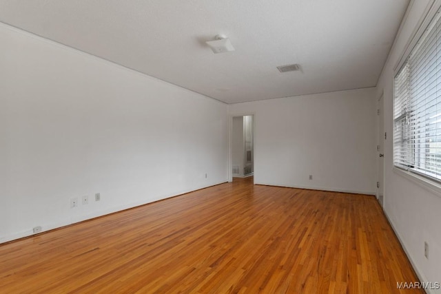 empty room featuring visible vents and light wood-style flooring