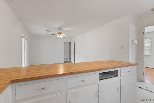 kitchen featuring ceiling fan, butcher block countertops, visible vents, and white cabinets