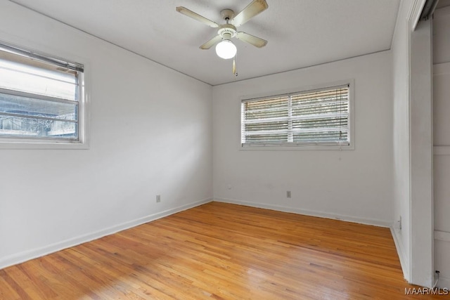 unfurnished bedroom featuring light wood finished floors, multiple windows, and baseboards