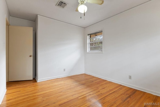 spare room with a ceiling fan, baseboards, visible vents, and light wood finished floors