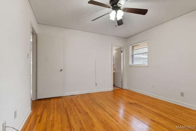 unfurnished bedroom with light wood-style floors, baseboards, and ensuite bathroom