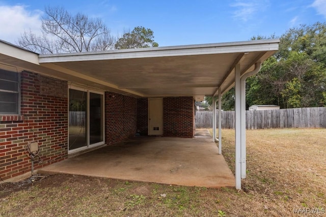 view of patio / terrace with an attached carport and fence