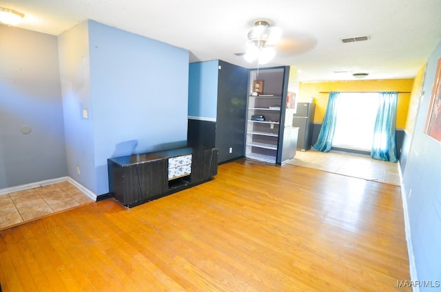 interior space with visible vents, baseboards, and wood finished floors