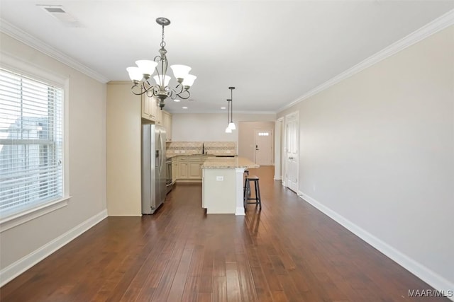 kitchen with crown molding, stainless steel refrigerator with ice dispenser, visible vents, dark wood-type flooring, and baseboards