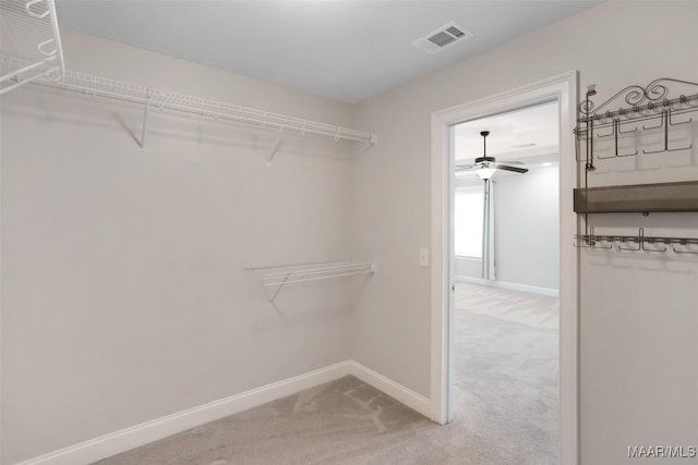 walk in closet with light colored carpet and visible vents