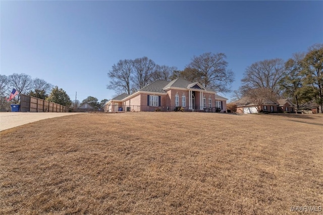 view of front facade with fence, a front lawn, and brick siding