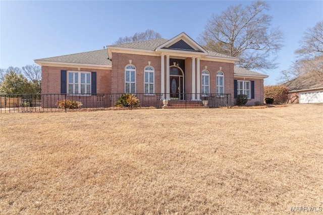 view of front of house featuring a front yard, brick siding, and fence