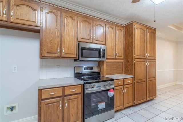 kitchen with light countertops, appliances with stainless steel finishes, brown cabinetry, and decorative backsplash