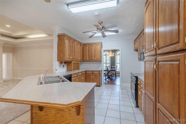 kitchen featuring a peninsula, a sink, brown cabinets, black electric range oven, and a kitchen bar