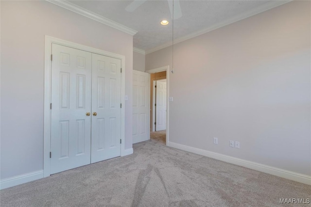 unfurnished bedroom featuring ornamental molding, a closet, carpet, and baseboards