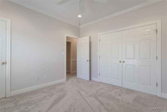 unfurnished bedroom with ornamental molding, a closet, carpet floors, and baseboards