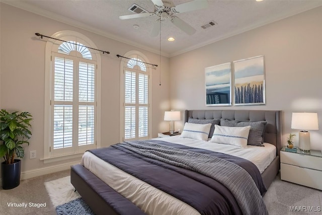 bedroom with carpet floors, visible vents, and ornamental molding