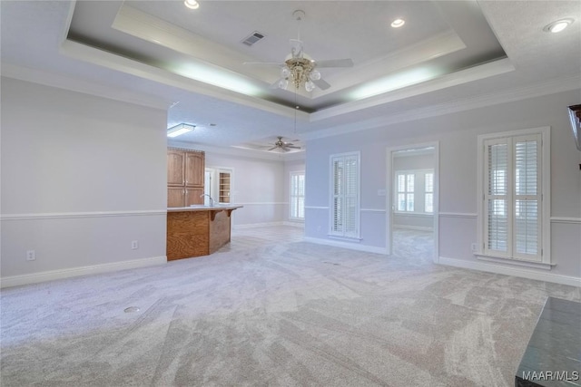 unfurnished living room featuring light carpet, a tray ceiling, and visible vents