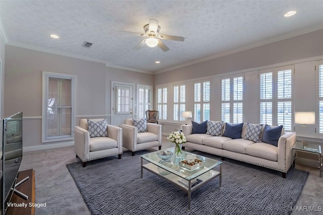 living room with a textured ceiling, ornamental molding, carpet flooring, and visible vents