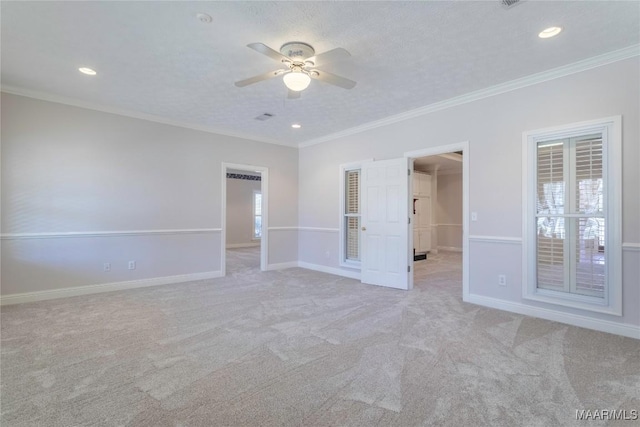 unfurnished bedroom featuring baseboards, light colored carpet, a textured ceiling, and ornamental molding